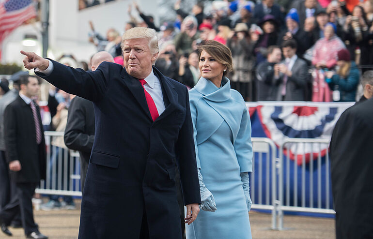 Pr&auml;sident Trump zeigt auf die Menge, w&auml;hrend er mit seiner Ehefrau Melania Trump an der Trib&uuml;ne der 58. Inaugurationsparade in Washington D.C. vorbeigeht.