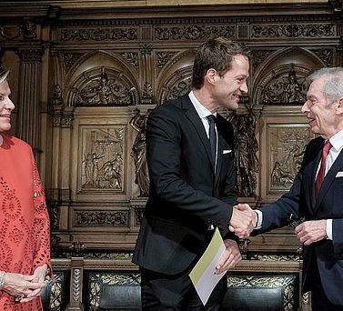 Der Akademiepr&auml;sident Prof. Dr. Edwin J. Kreuzer gratuliert Prof. Dr. Dr. Fabian Theis mit einem H&auml;ndesch&uuml;tteln. Eva-Maria Greve steht neben ihnen und schaut die beiden M&auml;nner l&auml;chelnd an