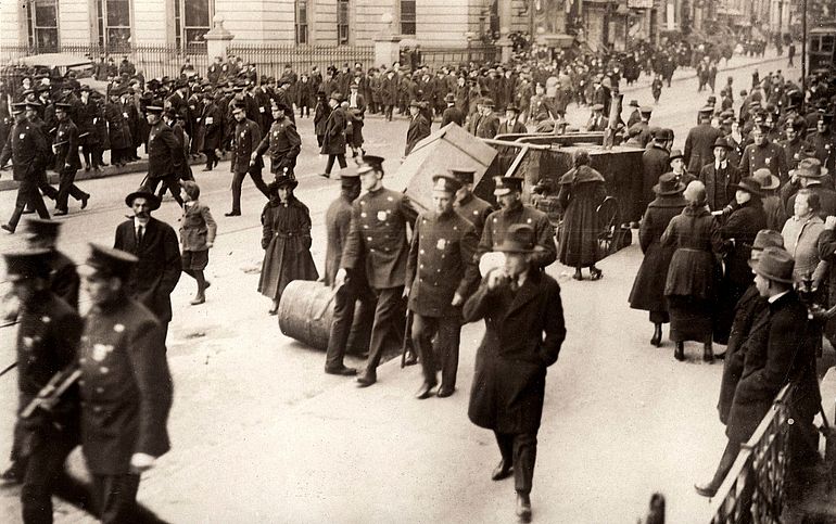 Prohibition in den Vereinigten Staaten von Amerika: Eine Stra&szlig;enszene mit einer gro&szlig;en Gruppe von Polizisten und beschlagnahmten Spirituosen. (1920) 