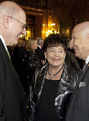 Akademiepr&auml;sident Prof. Dr. Heimo Reinitzer unterh&auml;lt sich mit dem Stifterehepaar Prof. Dr. h. c. Hannelore Greve und Prof. Dr. Dr. h. c. Helmut Greve inmitten der Besucher: innen der Preisverleihung. Alle drei l&auml;cheln.