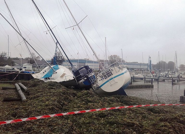 Durch das Ostseesturm&shy;hoch&shy;wasser am 20. und 21. Oktober 2023 in der Marina von Strande (Kreis Rendsburg-Eckernf&ouml;rde) auf Land geworfene Yachten