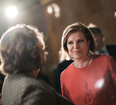 Eva-Maria Greve steht l&auml;chelnd zwischen Besuchern der Preisverleihung des Hamburger Wissenschaftspreises.