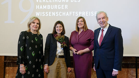 Vor einer Leinwand im Hamburger Rathaus stehen von links nach rechts: Stifterin Eva-Maria Greve, Preistr&auml;gerin Prof. Dr. Jutta G&auml;rtner, Zweite B&uuml;rgermeisterin und Wissenschaftssenatorin Katharina Fegebank und Akademiepr&auml;sident Prof. Dr. Edwin J. Kreuzer. Auf der Leinwand ist der Text &bdquo;Verleihung des Hamburger Wissenschaftspreises&ldquo; zu lesen.