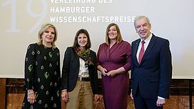 Vor einer Leinwand im Hamburger Rathaus stehen von links nach rechts: Stifterin Eva-Maria Greve, Preistr&auml;gerin Prof. Dr. Jutta G&auml;rtner, Zweite B&uuml;rgermeisterin und Wissenschaftssenatorin Katharina Fegebank und Akademiepr&auml;sident Prof. Dr. Edwin J. Kreuzer. Auf der Leinwand ist der Text &bdquo;Verleihung des Hamburger Wissenschaftspreises&ldquo; zu lesen.