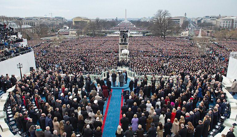 Die Amtseinf&uuml;hrung von Donald Trump vor dem Kapitol in Washington D.C aus der Sicht des US-Pr&auml;sidialamtes. Um ihn herum stehen zahlreiche Politiker und G&auml;ste, auch der Platz vor dem Kapitol ist gef&uuml;llt. Der Himmel ist bew&ouml;lkt.