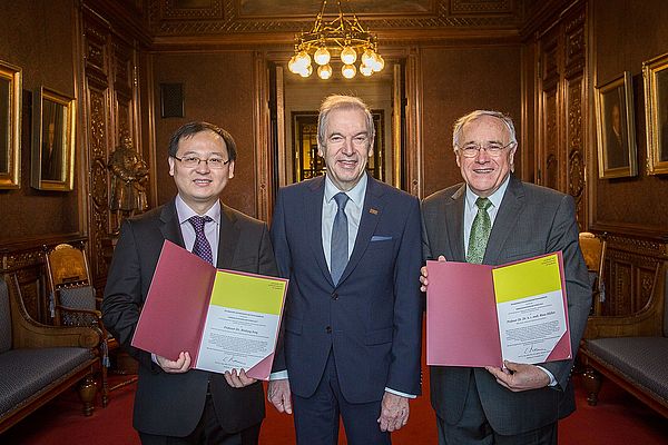 Die Preistr&auml;ger Prof. Dr. Xinliang Feng und Prof. Dr. Klaus M&uuml;llen halten ihre Urkunden f&uuml;r den Hamburger Wissenschaftspreis in den H&auml;nden. Akademiepr&auml;sident Prof. Dr. Edwin J. Kreuzer steht zwischen den beiden M&auml;nnern.