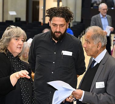 Akademientag 2023: Akademiepr&auml;sident Prof. Dr. Mojib Latif im Gespr&auml;ch mit Dr. Elke Senne, Referentin f&uuml;r Forschung. Zwischen den beiden ist der Soziologe und Bildungsforscher Prof. Dr. Aladin El-Mafaalani zu sehen.
