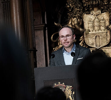 Laudator Prof. Dr. Christoph Bock steht hinter dem Rednerpult w&auml;hrend seiner Laudatio.