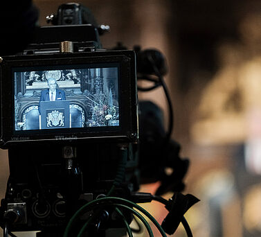 Auf dem Display einer Kamera ist Akadmiepr&auml;sident Prof. Dr. Edwin J. Kreuzer zu sehen. Er steht am Rednerpult und spricht zum Publikum.