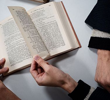 Forscher bl&auml;ttert Seite im Buch um